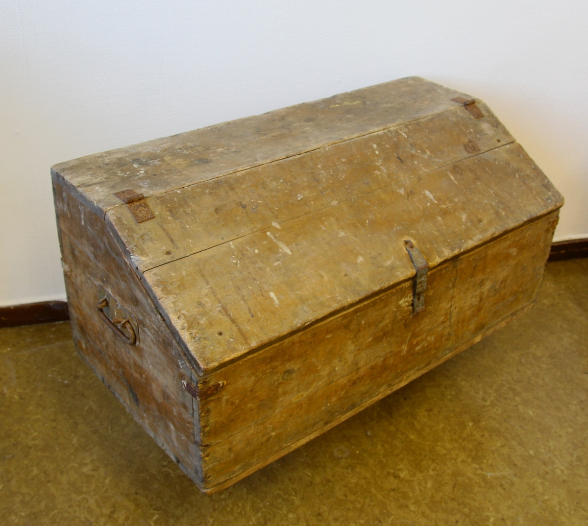 Verktøykiste av tre. Skråstilt lokk. Skuff øverst i rommet. Handtak på sidene.