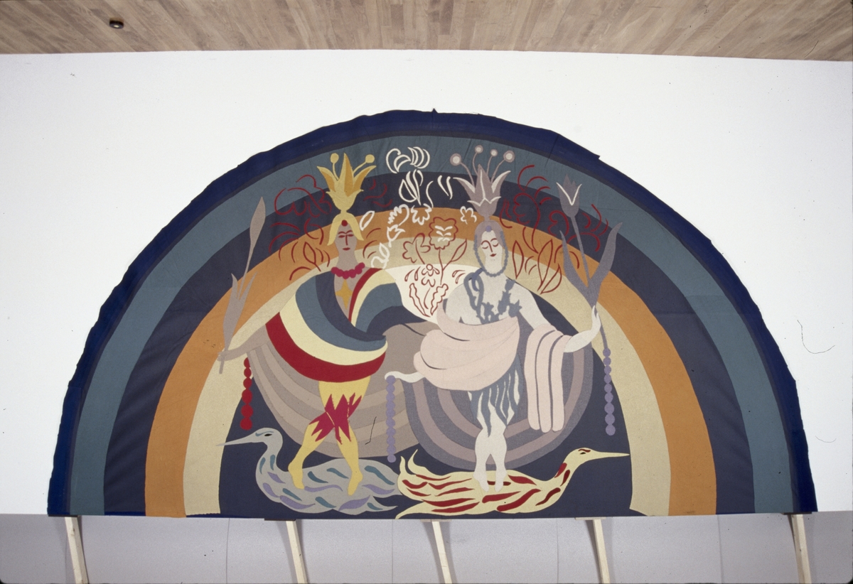 Halcirkelformad ylleapplikation med regnbåge i bakgrunden, Poseidon. Av färgade ylletyger efter skisser av Grünewald, Isaac.