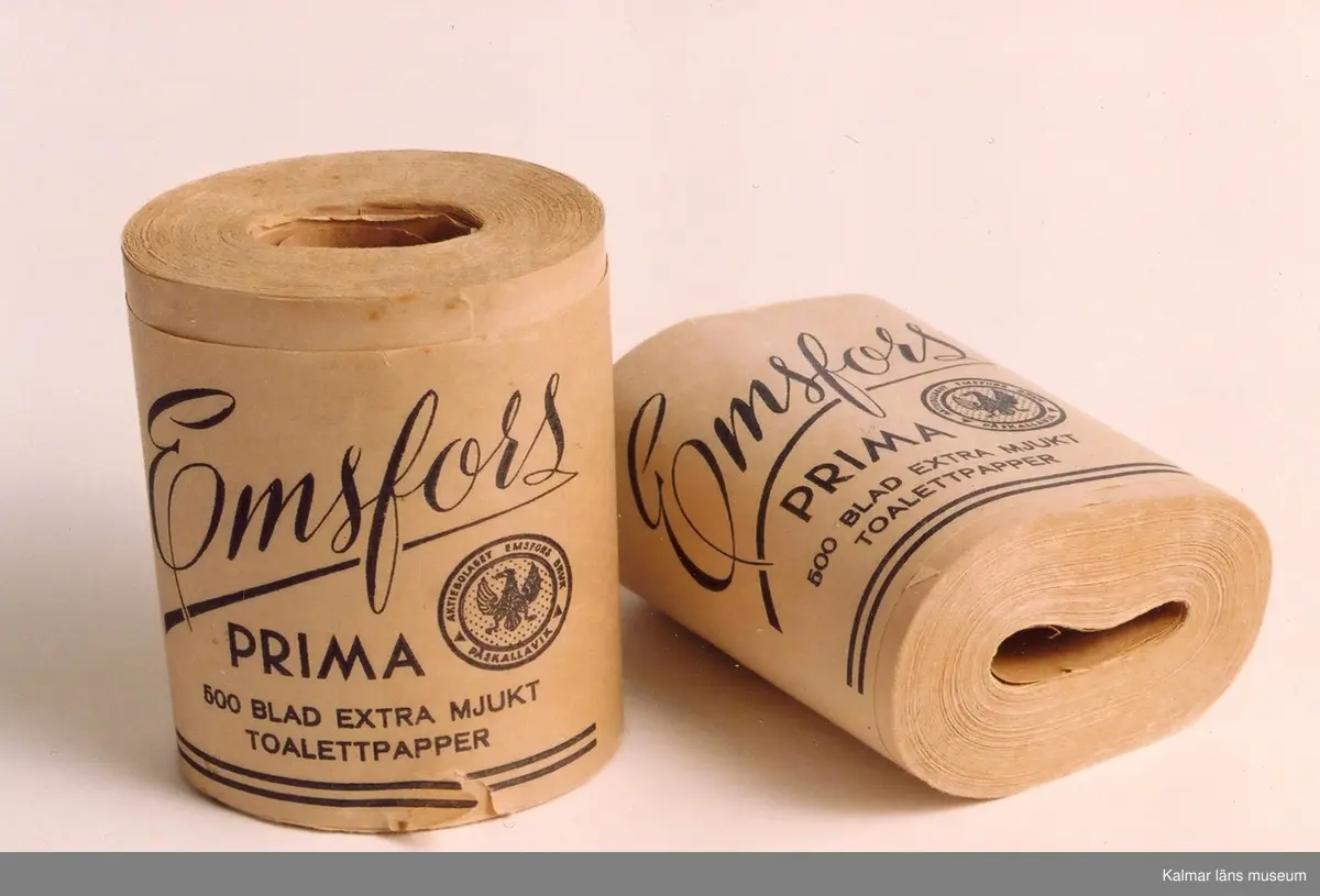 KLM 39616:1-2. Toalettpapper. Två stycken rullar. Tillverkade av Emsfors bruk. Rullarna försedda med text: Emsfors Prima 500 blad extra mjukt toalettpapper. Aktiebolaget Emsfors bruk, Påskallavik. Tillvaratagna på vinden inne på gården där Hugossons Eftr. hade sitt lager.