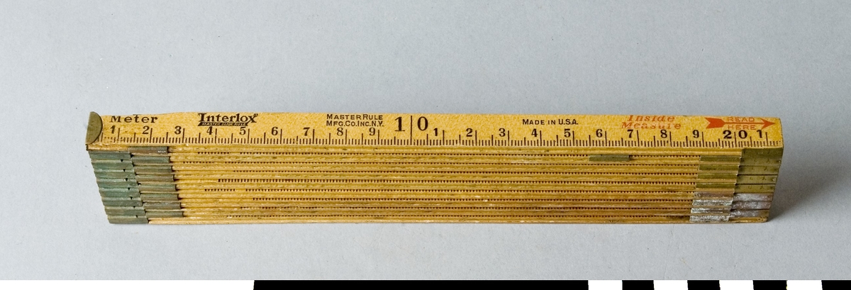 Meterstock av trä med vilken både ut- och invändiga mått kan tas. Den är 9- delad och har 1 ½ meters längd. Meterstocken är hopskjutbar. När den är hopskjuten är alla delar, förutom den första låsta. När den ska öppnas utdrages den första delen vilken då löser den andra o.s.v. På meterstocken är stämplat Interlox, MASTERSLIDE RULE, MASTERRULE, MFG CO. INC. N.Y. OUTSIDE MEASURE, PAT PEND. På sidan för invändigt mått står dessutom MADE IN USA samt i röd färg Inside Measure och READ HERE och en pil.

Funktion: Hopfällbar mätsticka