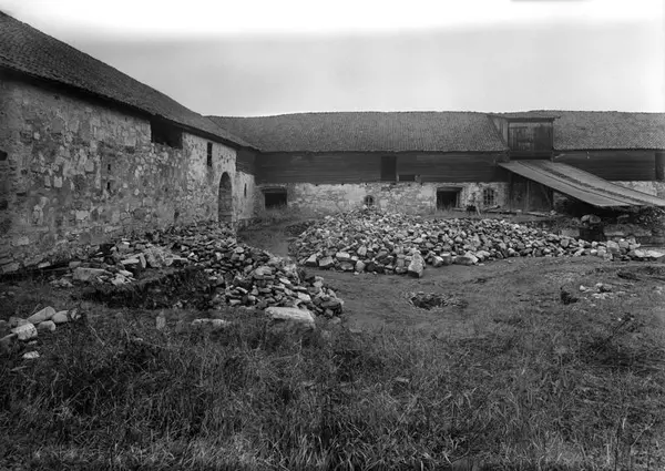Fotografi av steinhauger i borggården til Storhamarlåven før arkeologiske utgravninger av middelalderruinene her.
