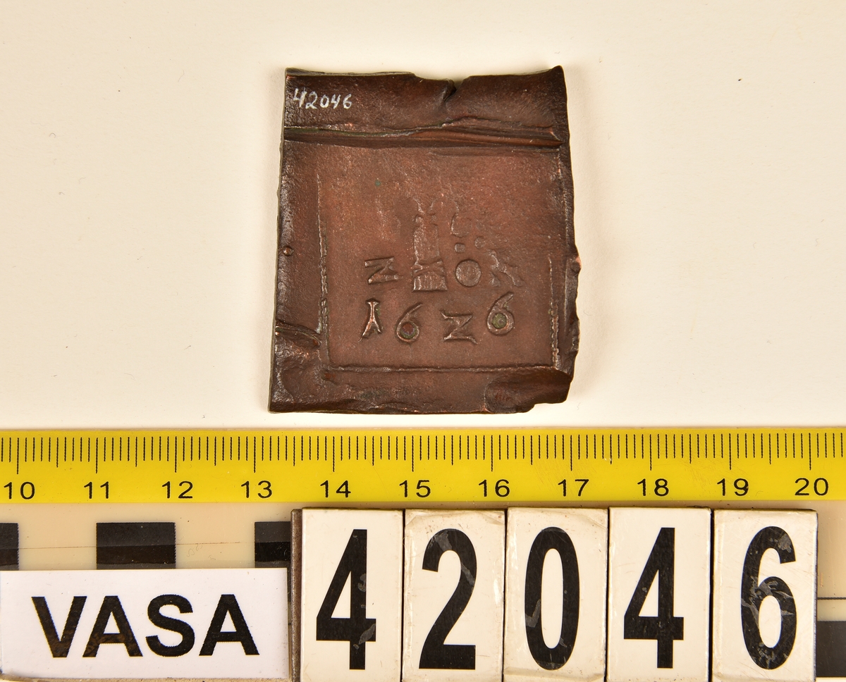 Ett fyrkantigt kopparmynt, s k klipping, med valören 2 öre.

På myntets åtsida syns versalerna G A R, placerade vågrätt mitt på myntet. Ovanför A:et är en krona svagt synlig. Under A:et syns versalen S. Åtsidans ram är delvis synlig. Präglingen är ocentrerad.
På myntets frånsida är en vasakärve svagt synlig. Till vänster om kärvens bas syns siffran två, i form av ett Z. Till höger om kärvens bas är versalerna ÖR delvis synliga. Längst ner på myntet står myntets präglingsår, 1626. Frånsidans ram är delvis synlig. Präglingen är ocentrerad.
Myntets vikt uppgår till 48,8 gram.
Myntets åtsida är krackelerad.

Text in English: Square-shaped coin. Denomination: 2 öre.
The obverse side has the initials G A R spaced horizontally in a row on the coin.  Above the initial A is a crown faintly  visible. Beneath the initial A is the initial S.
The coin stamp is off-centre. The frame is partly visible.
The reverse side has in the centre a Vasa sheaf, faintly legible. To the left of the sheaf is the numeral 2, shaped as a Z. To the right of the sheaf are the initials ÖR partly  visible.
The four digit year of coinage, 1626, is placed beneath the sheaf.
The coin stamp is off-centre. The frame is partly visible.
Present condition: the obverse side has a craquelure-like surface.
Weight: 48,8 gram.