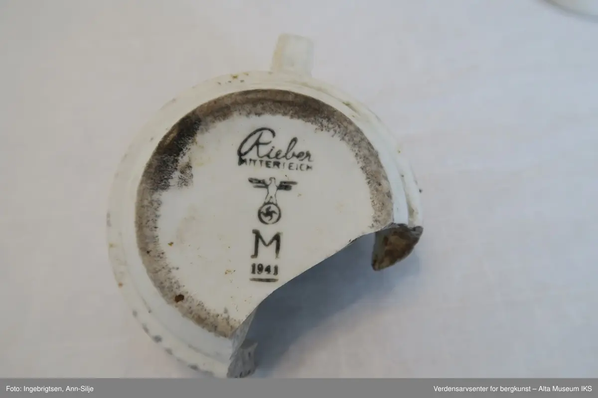 Hvite porselenskopper (3 stk) og -krukker (2 stk.). På undersiden er det stemplet med produsentmerke og emblemet til den tyske krigsmarine som består av et hakekors med en ørn over. Den ene krukken har et halvt lokk.