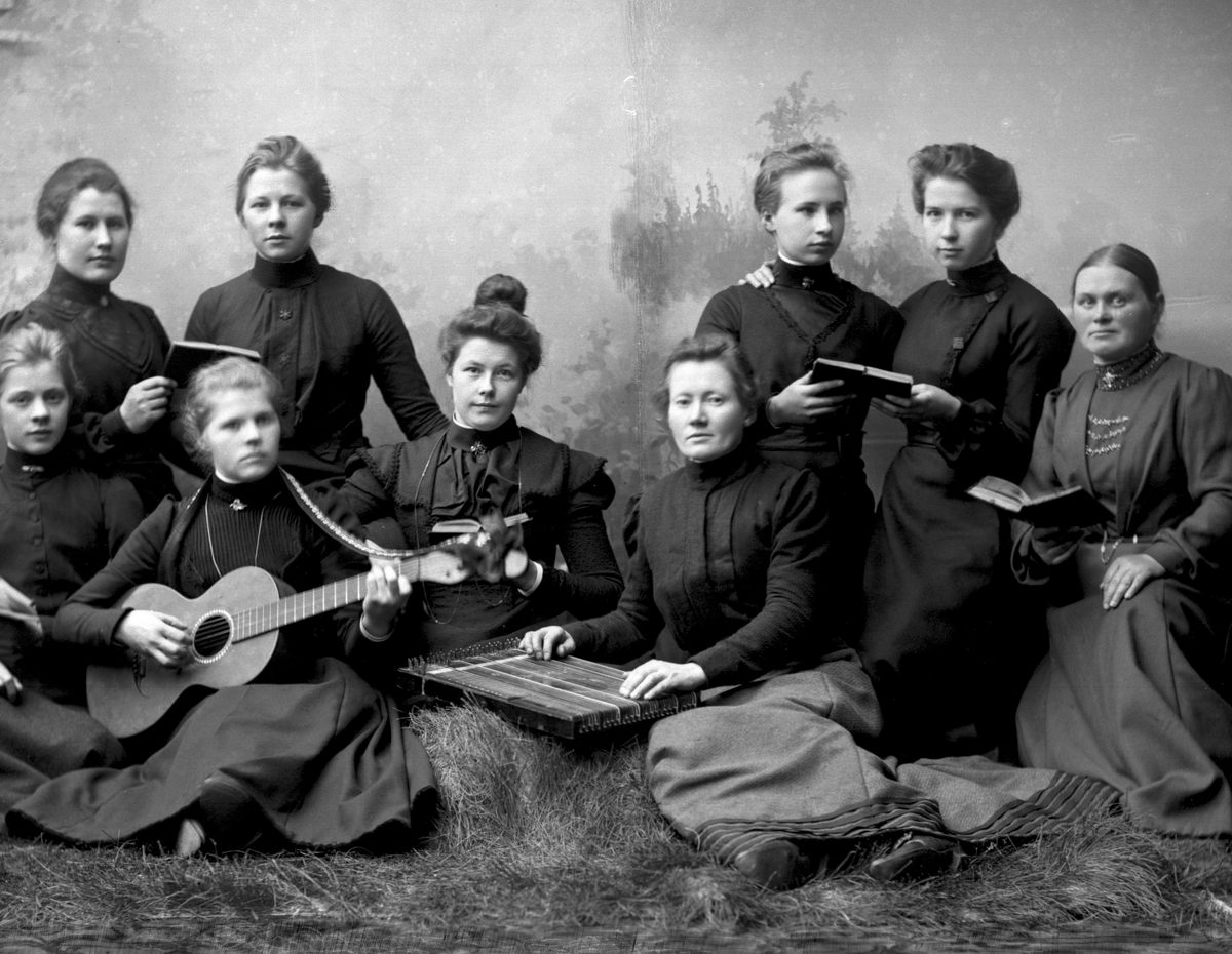 Gruppeportrett. Ni kvinner spiller gitar og zither og synger. Louisenberg.