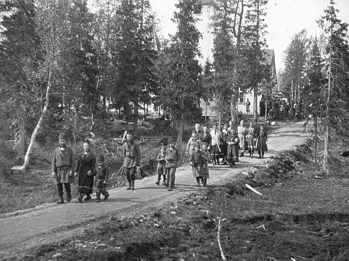 Mennesker på vei fra Majavatn kapell i Grane kommune. Koftene er sørsamiske.