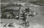 Flygbild över Locknevi kyrkan och bostadshus samt åkrar.