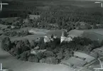 Vy över  Misterhult.Hembygdsgården Grönöstugan med kyrkan och åkrar samt skog.