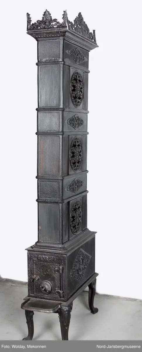Langside på ovnkammeret et liggende sirupsnippsornament med plantedekor, medaljong med halvfigur en face barokkmann? kvinne? Tverkkamrene  med medaljonger med et par i omfavnelse,  toppkrans med midtplassert lotusblomst med amorin med palmeblad. Svungne ben med planteornament.