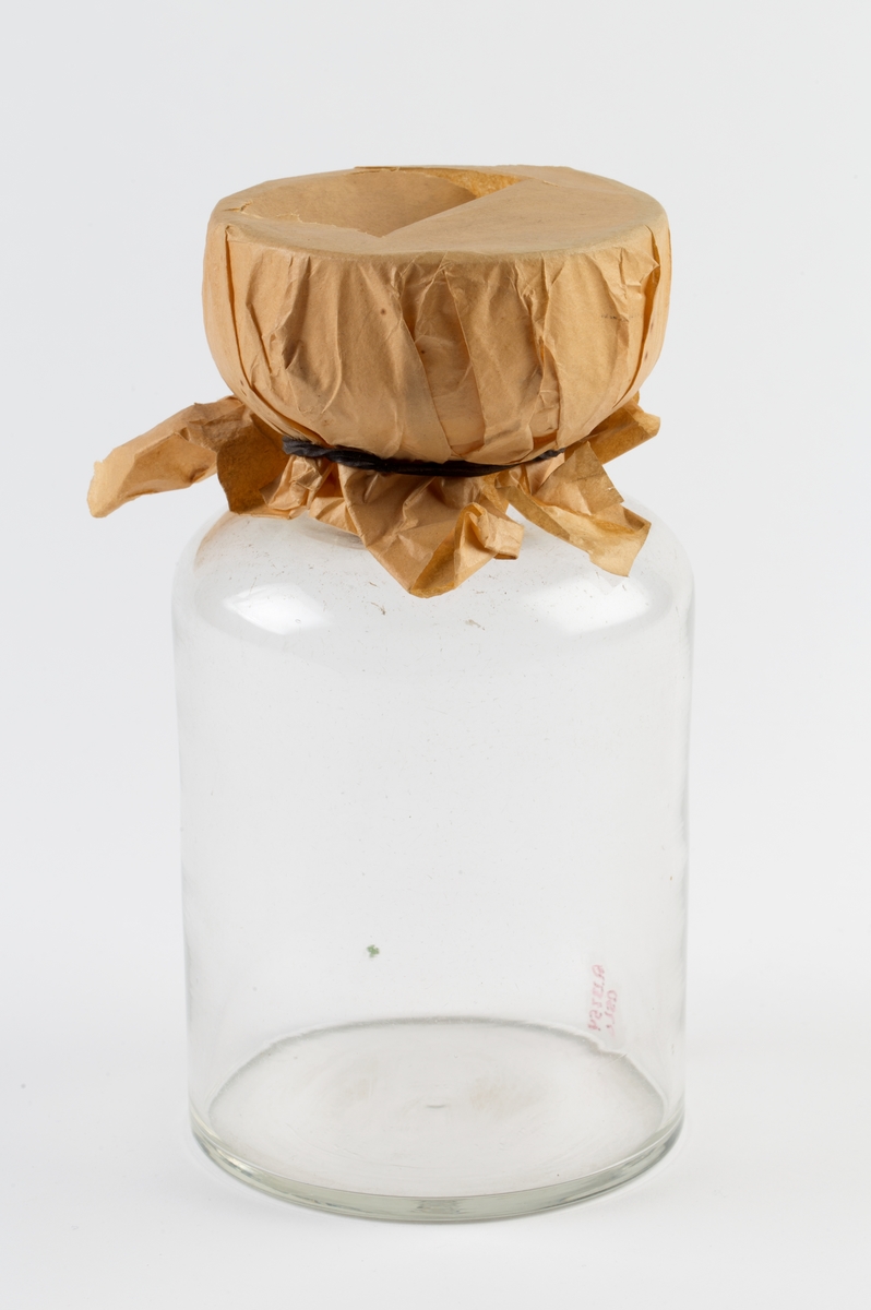 Glassflaske med vid, traktformet hals, overbundet med papir.