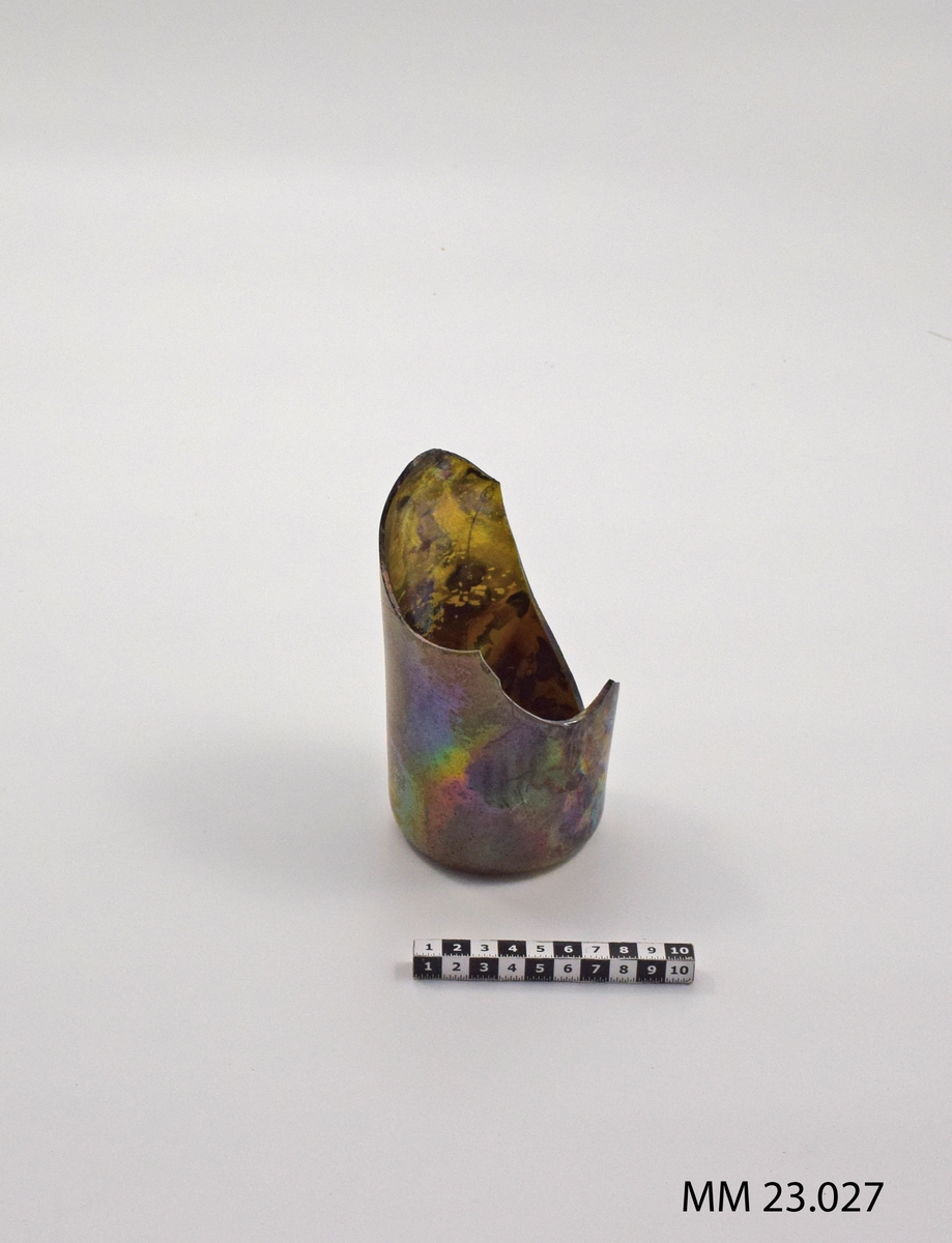 Flaska, sjöfynd från Nya Riga. Flaskan är till viss del krossad och endast botten är hel. Flaskbotten har en urgröpning inåt om cirka 40 mm. Föremålet är iriserat. Ytstrukturen med iriseringen är i bottenkanten något avskavd.