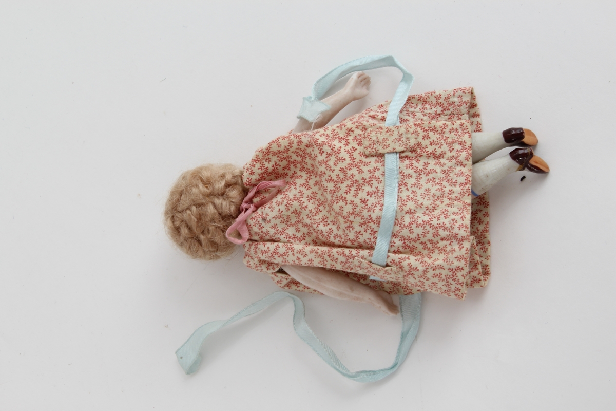 Ganske sikker giver: Karen Collett (f.1921)
To stykk små porselensdukker. Ene med kort krøllete hår, rød blomstrerte kjole med blått silkebånd og påmalt ansikt og sko. Den andre med langt lyst hår i brunprikkete kjole med blått silkebånd og påmalt ansikt og sko.