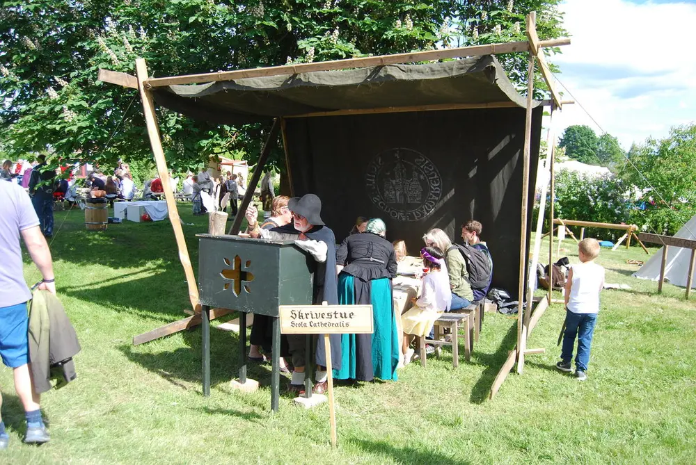 Mann som skriver med fjærpenn og blekk