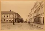 Drottninggatan österut, Stortorget till vänster och Enneska palatset vid Rådhustorget i fonden. Skyltar med texten 