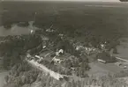 Flygfoto över Långemåla, Hornsö. Samhället Bebyggelse med bostäder och lantbruk, industri.