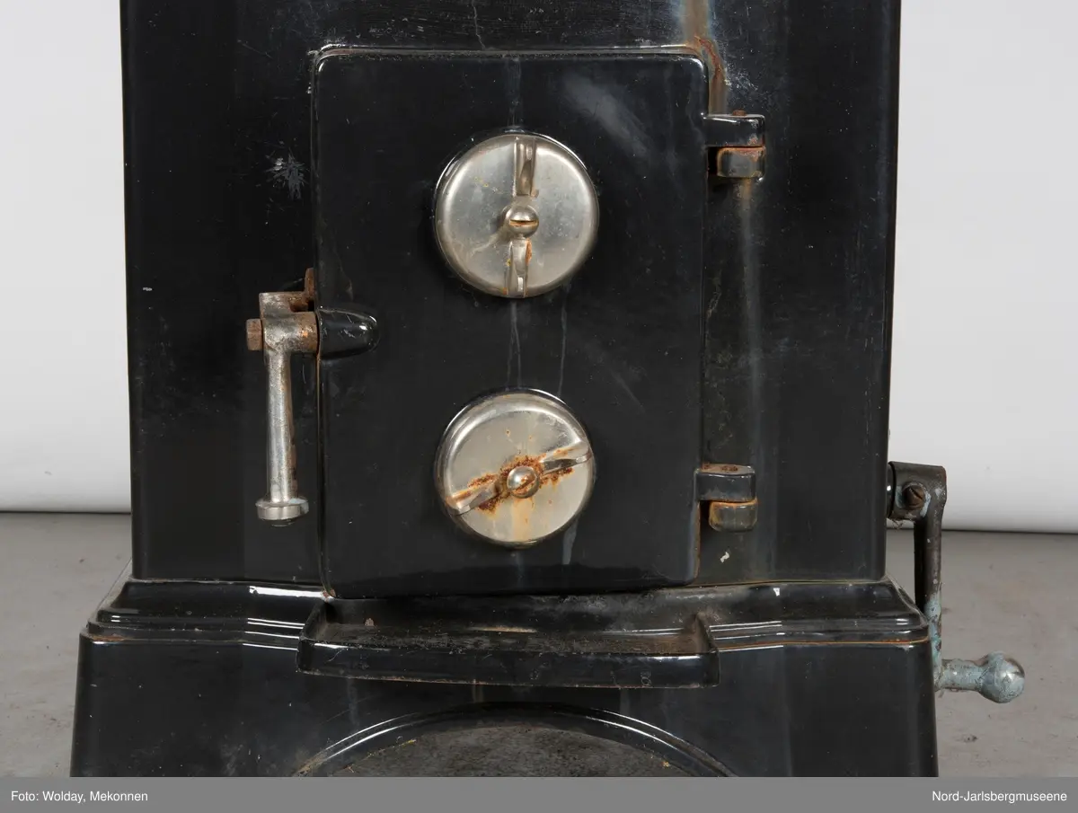 Relieffer: 1. på fronten: Askepott og prinsen som prøver om skoen passer. 2. På sidene: Askepott i grua med slottet i bakgrunnen. På grindene på dobbeltdørene til kokerom: en medaljong med grytemotiv, grinden med gjennombrutt labyrintmønster.