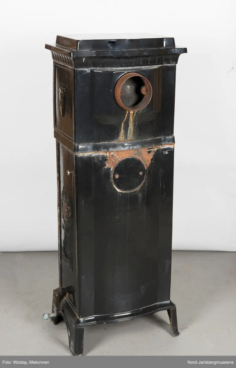 Relieffer: 1. på fronten: Askepott og prinsen som prøver om skoen passer. 2. På sidene: Askepott i grua med slottet i bakgrunnen. På grindene på dobbeltdørene til kokerom: en medaljong med grytemotiv, grinden med gjennombrutt labyrintmønster.