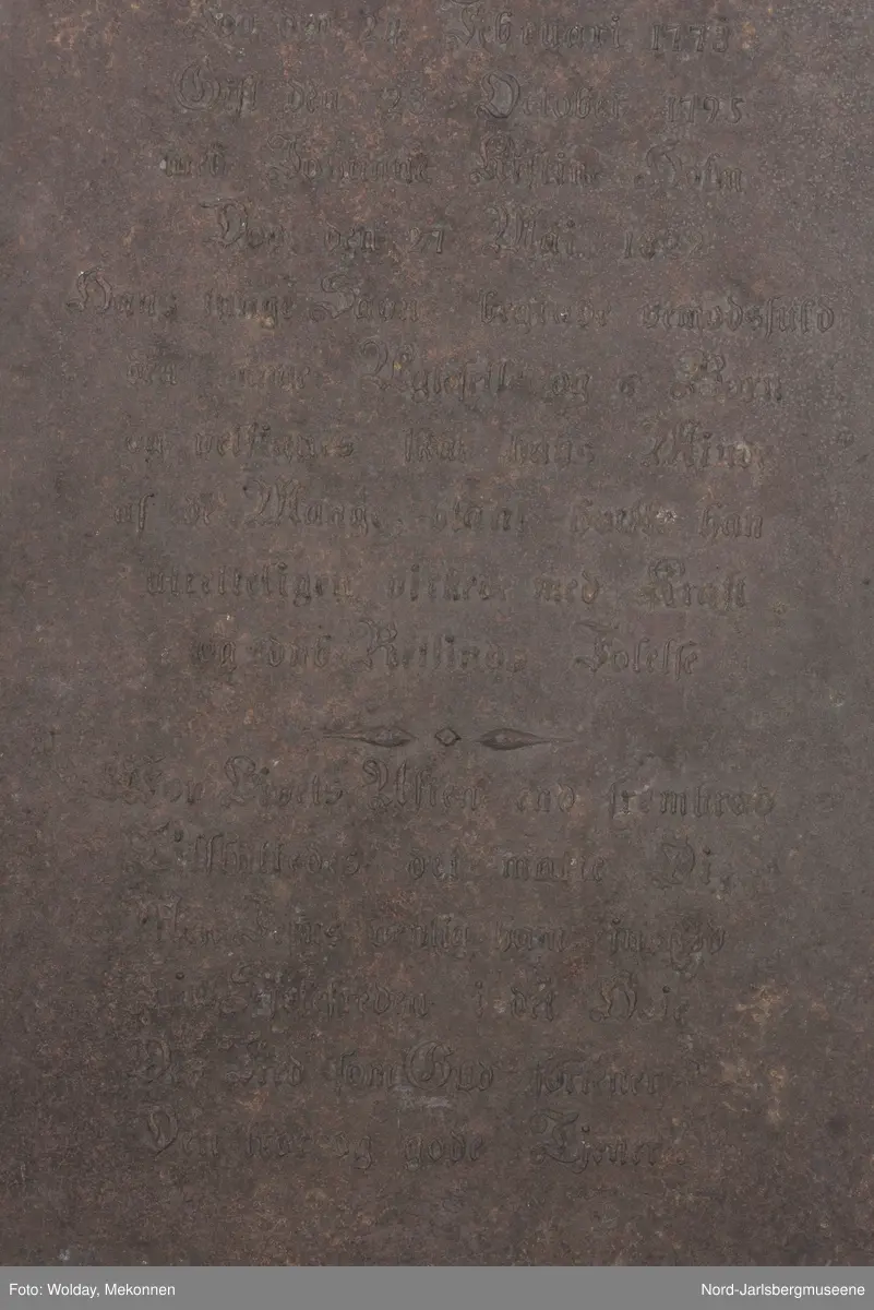 Noen enkle rosetter på her side av "af" øverst på platen. En svært forenklet girlander med rosett som deler teksten i to horisontale felt. Tekstinskripsjon ( se påført tekst merker)