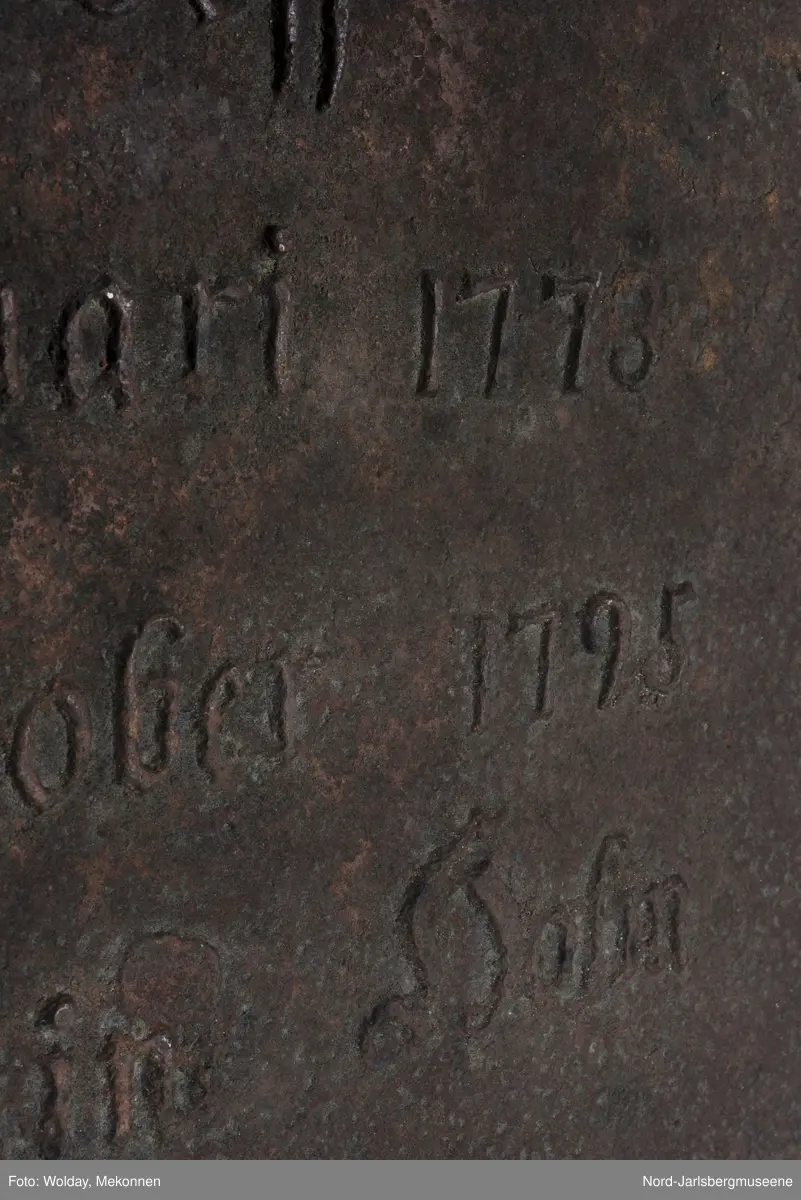 Noen enkle rosetter på her side av "af" øverst på platen. En svært forenklet girlander med rosett som deler teksten i to horisontale felt. Tekstinskripsjon ( se påført tekst merker)