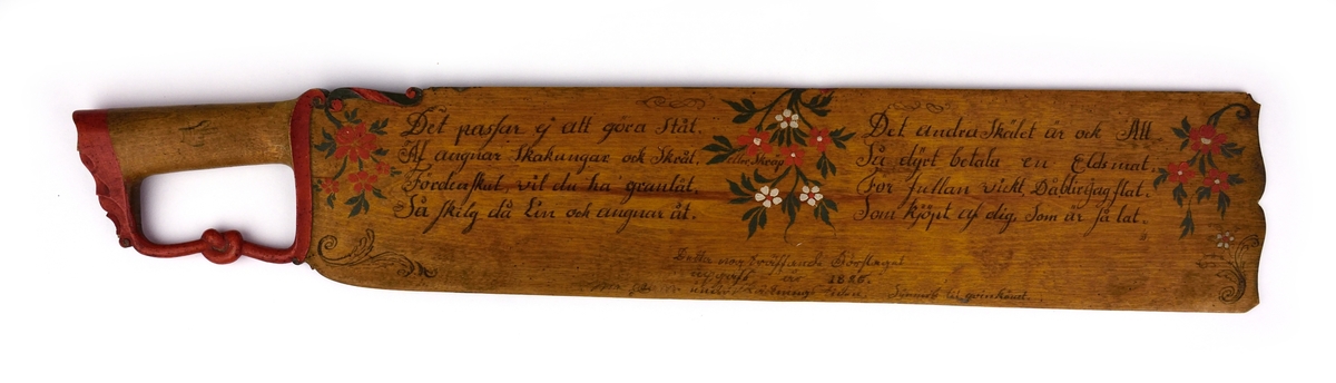 Skäktkniv av trä. På ena sidan av bladet finns blomsterornering i rött, vitt och grönt samt med bläck skrivna verser. Den andra sidan är omålad. På handtagets nederdel finns en snidad knut.