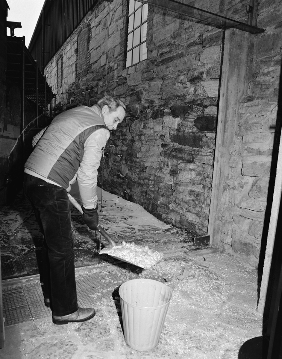 Arne Johnsen, rydder opp glass etter innbruddsforsøk i Storhamarlåven, januar 1983.