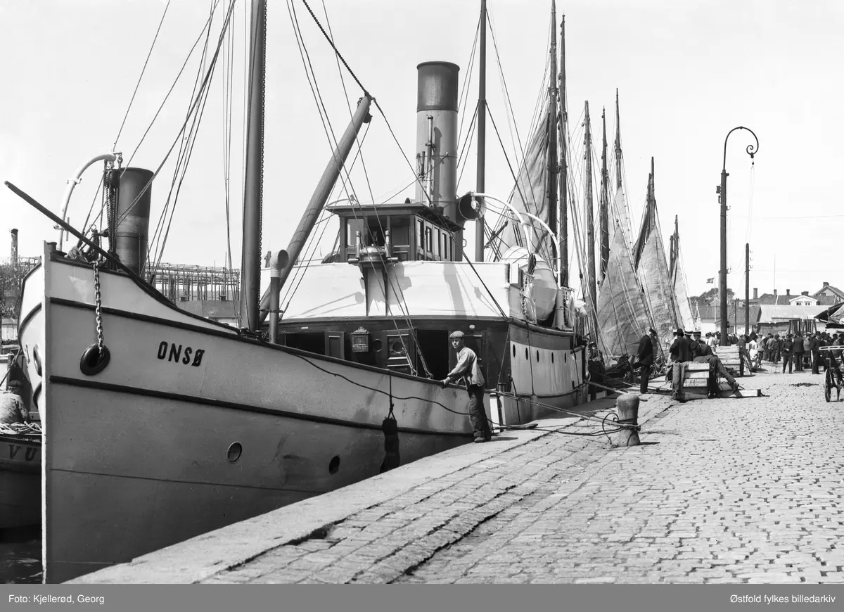 Dampbåten Onsø ved kai i Fredrikstad.
Det vi ser i bakgrunnen til venstre er beddingen ved Fredrikstad mekaniske verksted (FMV) med et rammeverk som ble benyttet ved bygging av skip.  Et rammeverk rundt hvor stillaser kunne bli festet til.