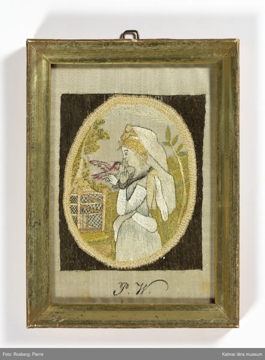 Dam med duva. Kvinna med duva i höger hand, till vänster i motivet en fågelbur.