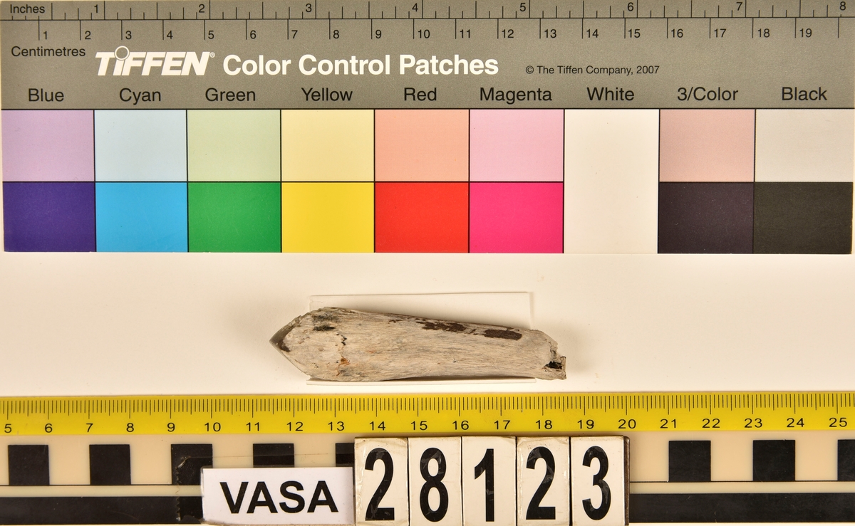 Fragment av horn. Avbruten i ena änden och sågad diagonalt till en spets i den andra änden. Ena sågytan har slipad sida. Hornets ursprungliga yta är bortnött och ytan känns närmast som torkat trä.