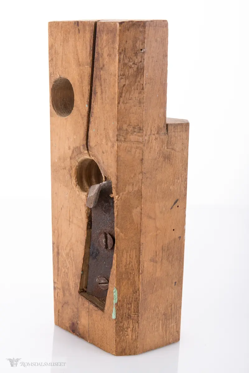Rektangulær trekloss. Gjennom klossen er det et gjenget hull med høveljern i for å kunne høvle ut gjenger på et emne.
