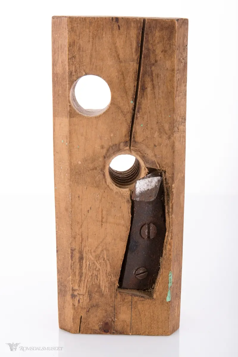 Rektangulær trekloss. Gjennom klossen er det et gjenget hull med høveljern i for å kunne høvle ut gjenger på et emne.