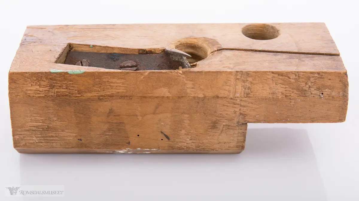 Rektangulær trekloss. Gjennom klossen er det et gjenget hull med høveljern i for å kunne høvle ut gjenger på et emne.