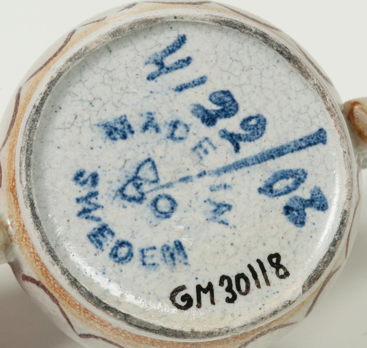 Bägare av lergods. Bo Fajans, design Eva Jancke­Björk. Grå S­svängd med stora hänklar, ljus- och mörkbruna partier nedtill samt dekor av en blomma.