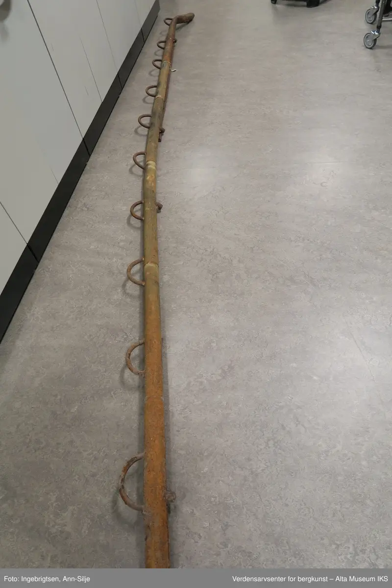 Sperrestang laget av stålrør. Stanga er sammensveiset av 7 stålrørsdeler og i hele lengden påsveiset et 15 mm rundjern og på motsatt side 10 halvsirkelformet stålbøyler som er regelmessig etter hverandre.