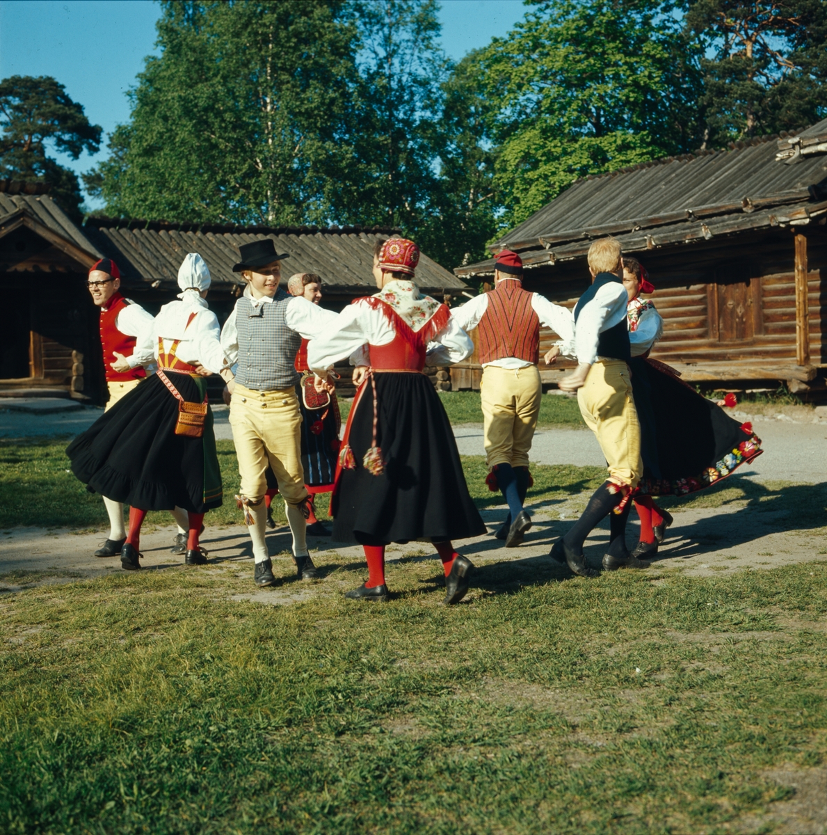 Ett folkdanslag dansar på Moragårdens gårdsplan.