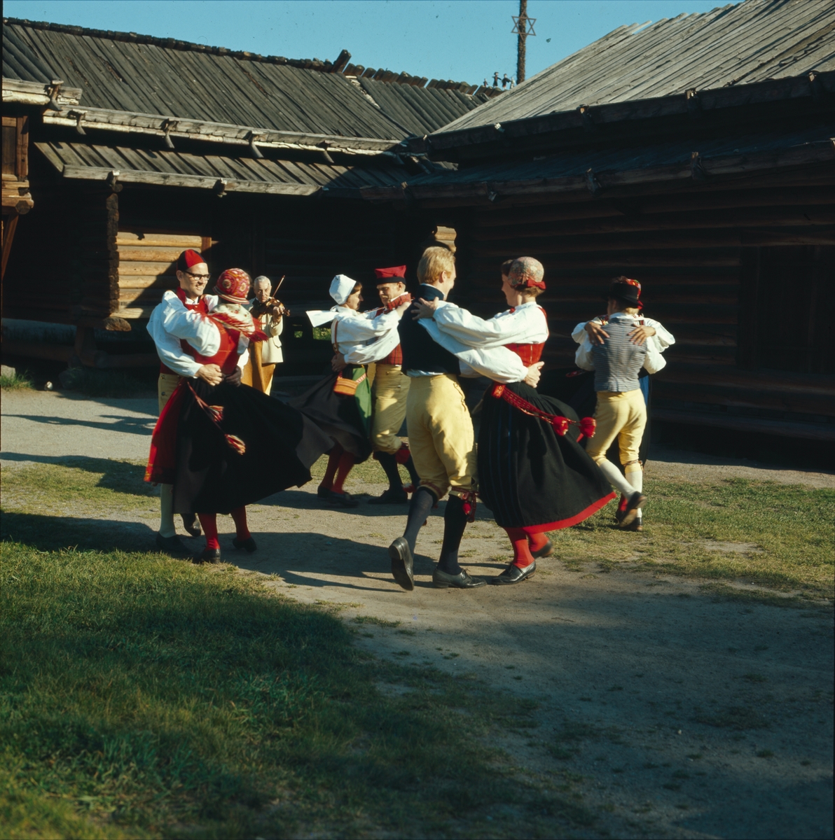 Ett folkdanslag dansar på Moragårdens gårdsplan.