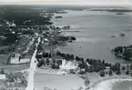 Flygfoto över Påskallavik. Samhället med kyrkan och bostadshus samt Kalmarsund.