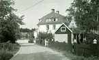 Bostadshus med garage, bakom ett staket vid en väg i Påryd. En bil står parkerad.
