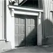 En port med trädörrar vid bostadshus.