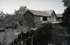 Gärdsgård och ekonomibyggnad med korsknut.