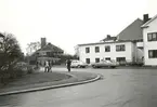 Trädgårdsgatan 1-3, till höger Strandgatan. Bostadshus, folk och bilar.