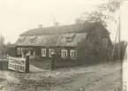 Huvudbyggnaden sedd från landsvägen. Tegel i övre tackfacket, bräder i undre.