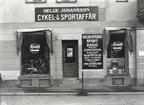 Helge Johansson Cykel och Sportaffär.
Helge Johanssons Sportaffär låg vid östra sidan av stadshusplan, där senare kommunhuset Balder byggdes. Affären övertogs i mars 1935 av köpman Helge Johansson, som fram till 1960 under skicklig och framsynt ledning avsevärt utvidgade verksamheten. Firmans försäljning omfattade nu inte bara sportartiklar, utan även cyklar. mopeder och motorcyklar, såväl som radio och TV. En väsentlig gren av verksamheten var serviceverkstaden.för vilken Astor Magnusson var chef. Helge Johansson kom från Västsverige. Efter  hans död fortsattes firman av Astor Magnusson. Fastigheten revs  i januari 1980, men då hade Cykel och Sportaffären flyttat till Kalmar.
(Källa : Gerhard Köppen)