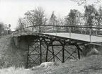 Bro över järnvägen vid Åsarna. Balkbro med stativ av hopfogade räler i tre spann.