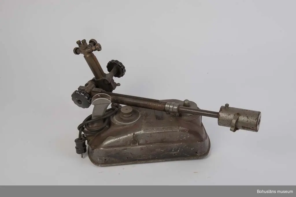 Skärbrännare för skärning av tjock stålplåt av fabrikat AGA. På ovansidan en plåt med ingjutna texten: 
AGA LIDINGÖ SWEDEN
KV - 560 / 1780 / 127 Volt
Reglage på ovansidan med rund skala med siffrorna 1 till 10.
Ställbart munstycke på ledbar arm med motvikt och som kan justeras med milimeterpassning enligt skala.
Vippkontakt med text: Till /Från
Märkt med tuschpenna: SÖRVIK