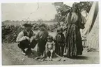 Zigenarfamilj (Dimitrios Taikon?). Foto 1924 från lägret vid Nyhem, (på Skälbys ägor) Kalmar. Övriga romska familjer avvisades från Kalmar stad. Denna familj fick stanna, då mannen fått blodförgiftning i händerna och behövde läkarvård.