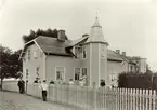 Foto av Hans Rydbergs farfars hus, byggt i början av 1900-talet. Fr. v. ses utanför grinden Alfred Rydberg (farfadern), innanför staketet: Erik Rydberg (fadern) med sonen Tor Rydberg  f. 1907. Utanför staketet nr. 4 fr. v. Oskar Rydberg (Kusin till HR), nr 5 fr.v: Annie Rydberg (farmodern), därefter ett par mostrar till Hans Rydberg, vid källartrappan Julius Rydberg. På trappan: Hans Rydbergs mor Mimmi Rydberg med sonen Bengt i famnen.
Fotot taget 1909.