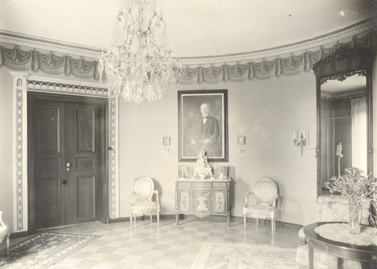 Ruda herrgård.  Bordsur i empire, helförgylld brons, sittande Amor, signerad Vorcacheux Hera Paris. Porträtt av brukspatron Björnström, ägarens far, olja på duk.
