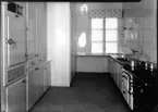 Hypermodernt kök från 1940 med kylskåp och rostfri diskbänk.