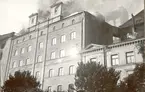 Ångkvarnsbranden 1935-07-06. På denna bild från Proviantgatan ses brandmän i färd med att släcka i ventilationen på taket.