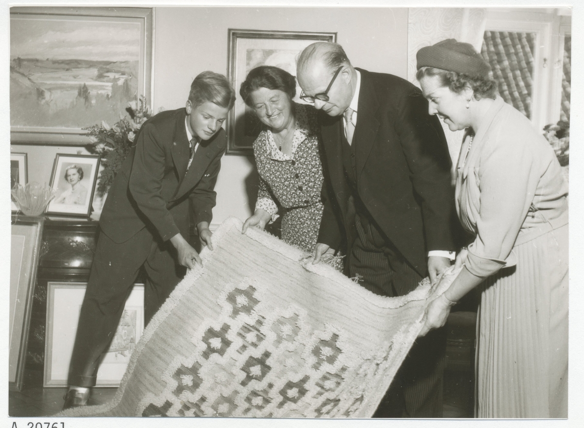Carl XVI Gustaf, landshövding Ruben Wagnsson, Helga Wagnsson och förmodligen Ingrid Björnberg ihållandes en matta.