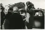 Kronprins Gustaf Adolf (till höger) och kronprinsessan Louise samt Landshövdingeparet Falk utanför färjeläget vid Ölandshamnen. 1940-talet.
I bakgrunden ses Odd Fellow-huset.